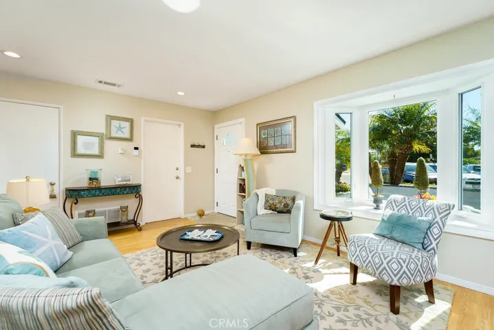 Front Livingroom with custom added bay window, a cozy white brick fireplace and recessed lights.