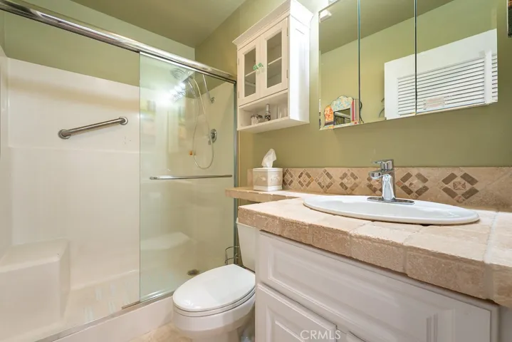 Primary bathroom with newer Vanity and tumbled travertine tiles.