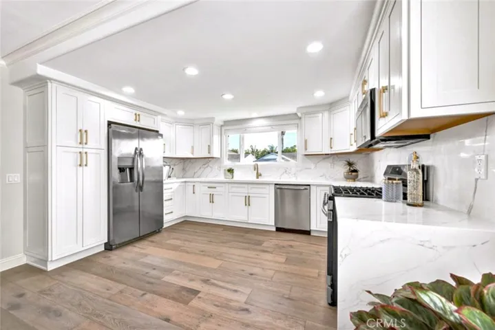 Fully remodeled kitchen with quartz slab countertops, stainless steel appliances, and custom cabinetry.