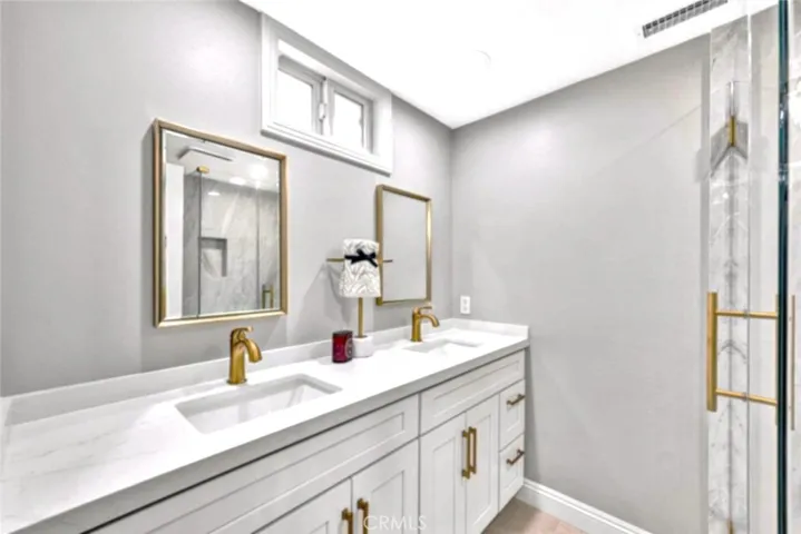 Elegant primary bathroom with dual vanity, granite counters, and designer fixtures.