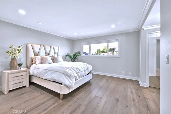 Spacious master bedroom with recessed lighting, engineered wood flooring, and generous layout.