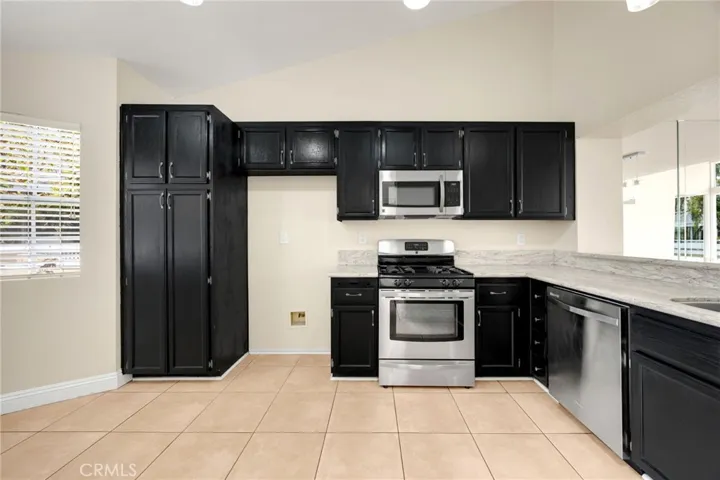 Modern kitchen is spacious and has room for a small bistro or mobile island.