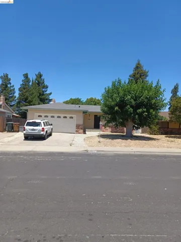 View of front of property with a garage, concrete driveway, and stone siding