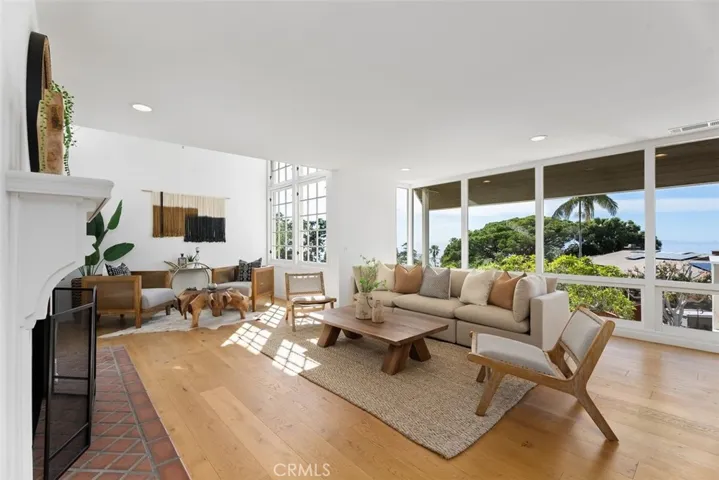 Living room with plenty of glass and natural light includes a unique architectural design with vaulted ceilings at the end of the room.