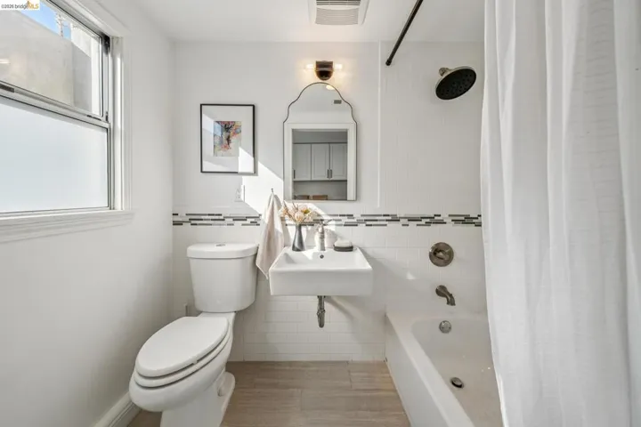 Bathroom featuring tile walls, shower / tub combo, and plenty of natural light