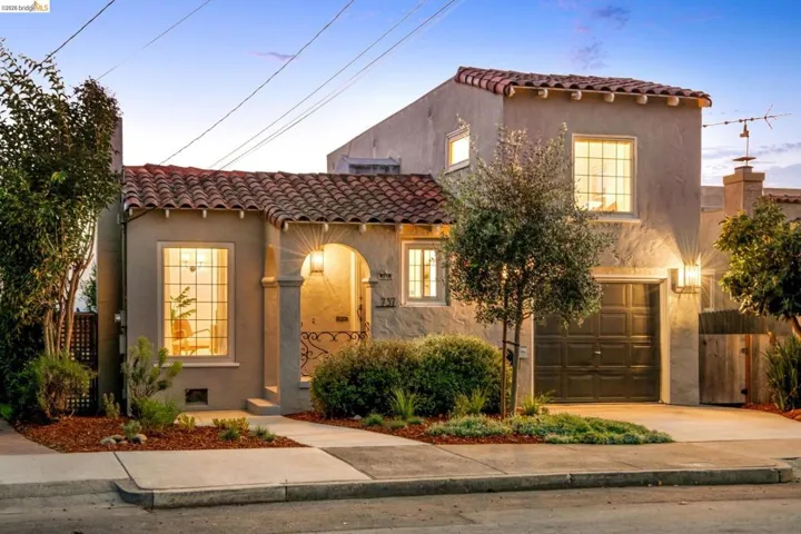 Mediterranean / spanish-style house featuring a tiled roof, stucco siding, an attached garage, and concrete driveway