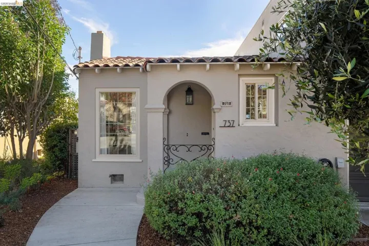 View of front of property featuring a tile roof, a chimney, and stucco siding