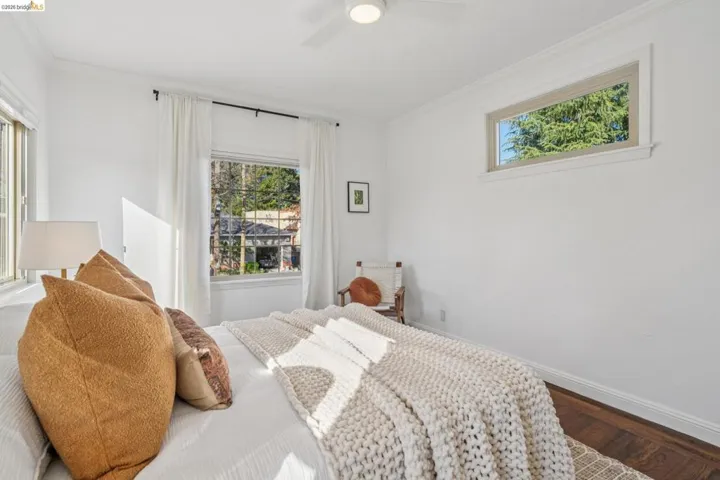 Bedroom featuring crown molding, dark wood-style flooring, and a ceiling fan