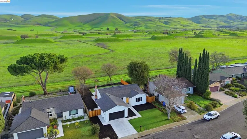 Overview of rural landscape with nearby suburban area and a mountainous background