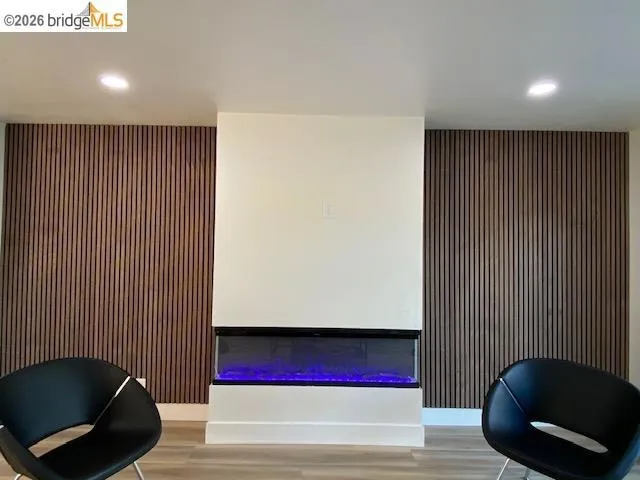 Sitting room featuring an accent wall, recessed lighting, and light wood-style flooring