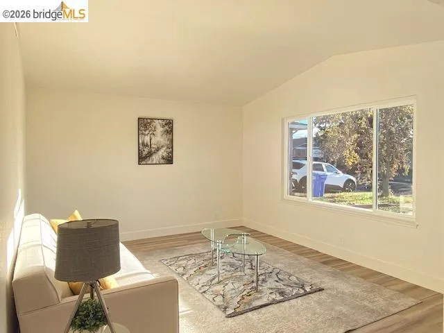 Living area featuring vaulted ceiling and light wood-type flooring