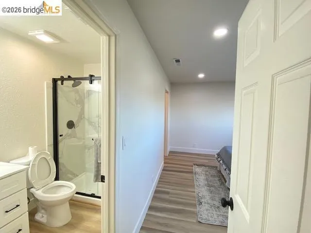 Bathroom featuring vanity, light wood finished floors, a shower stall, and recessed lighting