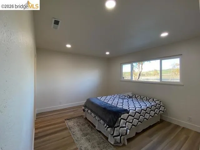 Bedroom with wood finished floors and recessed lighting