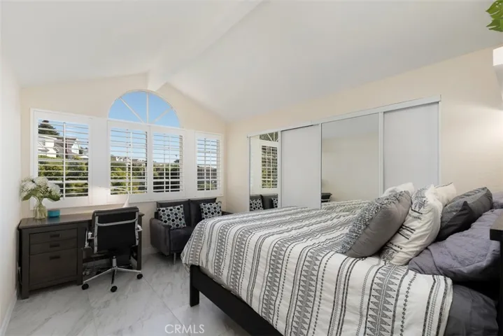 A fabulous guest room and office with views to the east side of home facing lush landscaping.