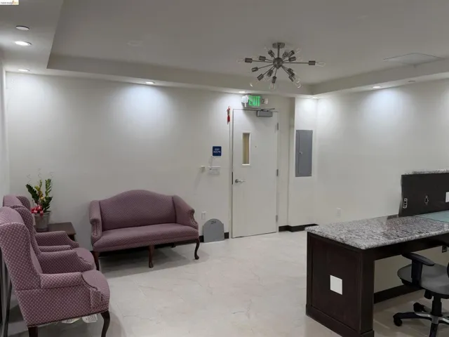 Home office with recessed lighting, electric panel, and a raised ceiling