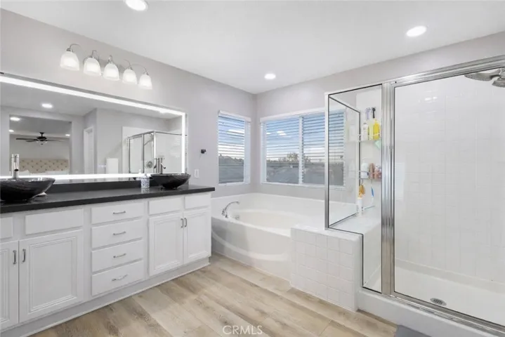 Master bathroom with dual vanity sinks and spacious walk in shower. View is backing the large dual walk in closets.