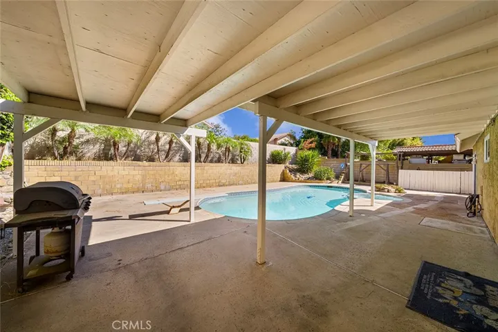 L-shaped covered patio to enjoy all year long. Sparkling pool with diving board to jump right in.