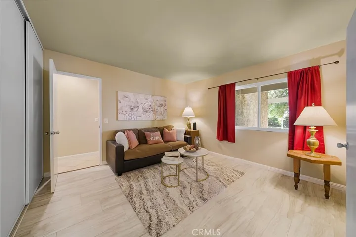 One of four bedrooms with double doors from the entry. Window faces the front yard. Door in the distance leads to the hallway with remaining bedrooms and laundry and door to the garage.