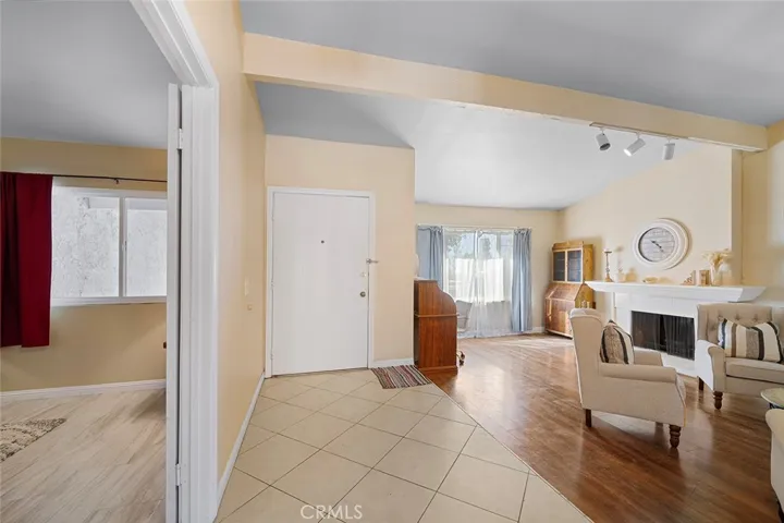 Entry, one step down to the formal living with fireplace. Left of image: double doors to one of four bedrooms which could also be used as a den or guest room or how you wish to use. Fireplace adds ambiance and warmth to conversations.