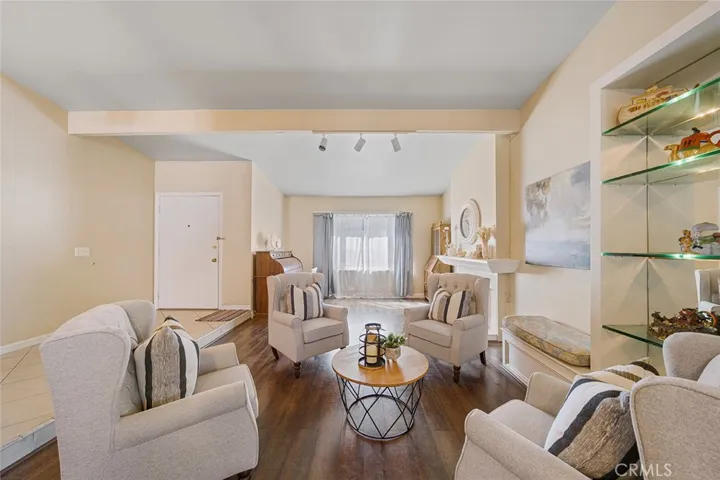 View from the dining area of the formal living room with formal entry. Built in glass shelves with lighting and side bench.