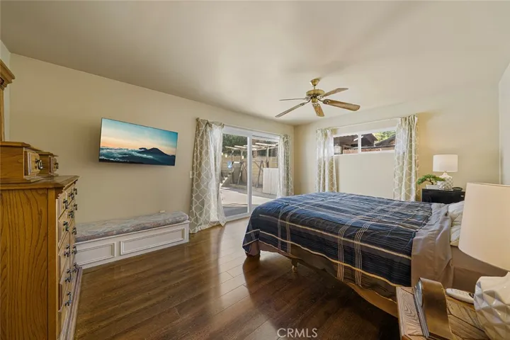 Roomy primary  bedroom with ceiling fan and sliders to the pool and hot tub.