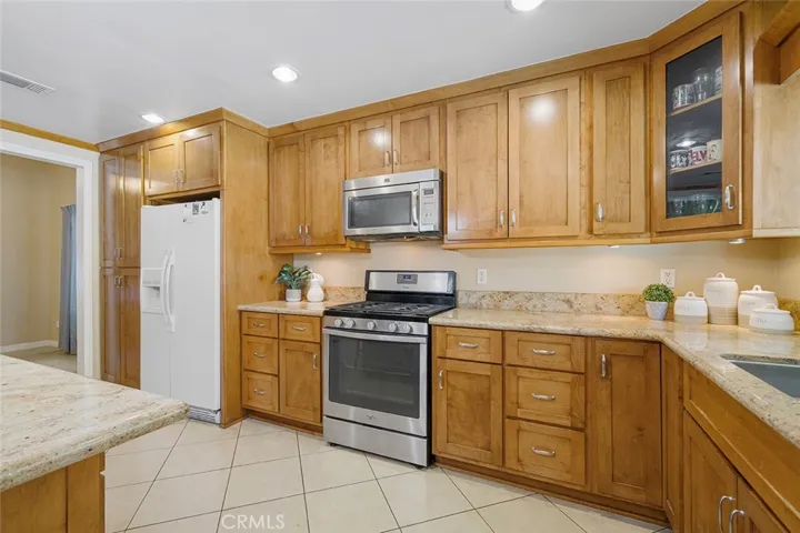 Beautiful cabinets and granite counters. Glass door to one of the cabinets to showcase pretty dishes and decor as desired. Throughway to the formal dining left of the image.