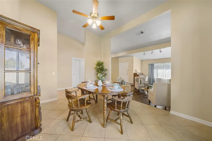 High ceilings and spacious formal dining one step up from the formal living room. Double doors in the distance leads to one of four bedrooms. Entry in the distance.