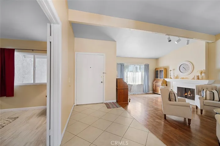 Entry, one step down to the formal living with fireplace. Left of image: double doors to one of four bedrooms which could also be used as a den or guest room or how you wish to use. Note that the fire is photoshopped in the fireplace.