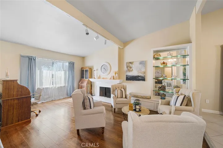 Formal living room with built in shelves with lighting and side bench. Fireplace adds warmth and ambiance.
