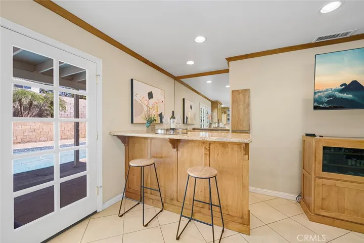 Wet bar adjacent to the French doors make it a perfect spot to hang out and watch a favorite show. It could be a great coffee hub if desired.