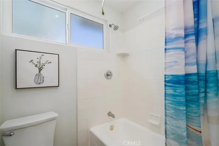 Primary private commode and shower in tub.