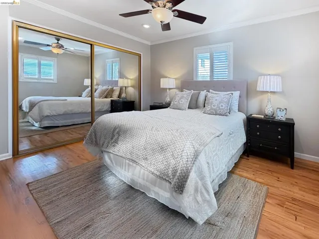 Bedroom with ceiling fan, a closet, light wood finished floors, crown molding, and recessed lighting