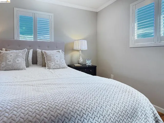 Bedroom with crown molding and baseboards