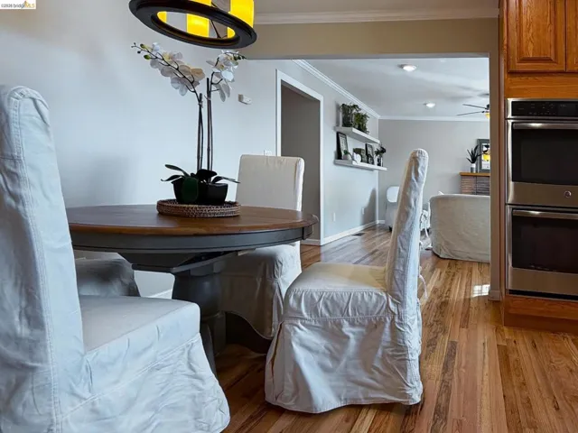 Dining space featuring light wood finished floors and ornamental molding