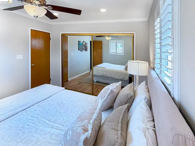 Bedroom featuring ornamental molding, a ceiling fan, wood finished floors, a closet, and recessed lighting
