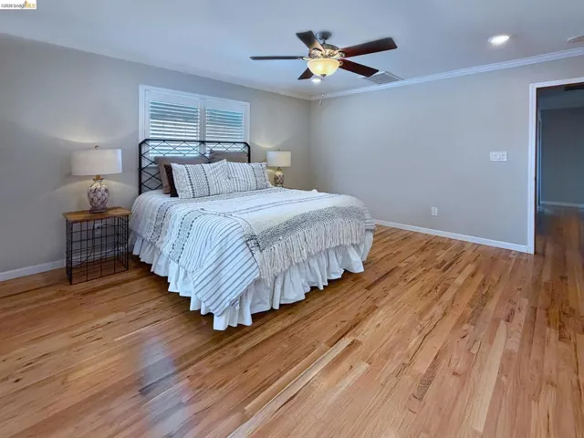 Bedroom with light wood finished floors, a ceiling fan, ornamental molding, and recessed lighting