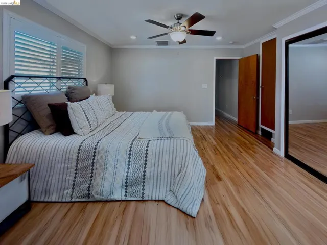 Bedroom with light wood-style floors, ornamental molding, a ceiling fan, a closet, and recessed lighting