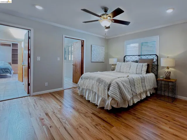 Bedroom featuring light wood finished floors, ornamental molding, a ceiling fan, and recessed lighting
