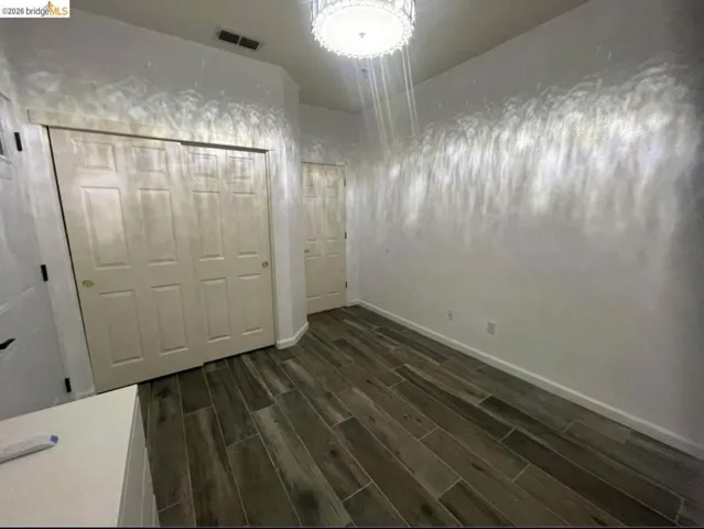 Unfurnished bedroom with wood finish floors and a closet