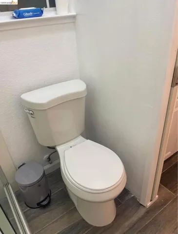Bathroom featuring wood finish floors and toilet