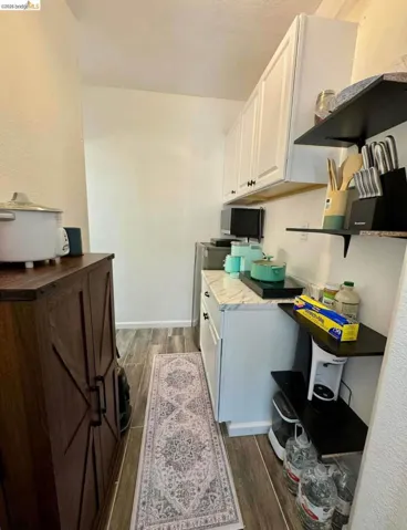 Kitchen with wood finish floors and white cabinets