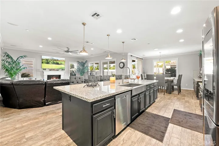 Luxurious custom kitchen and great room:
This expansive, open-concept great room showcases a designer kitchen with premium stainless-steel appliances, double ovens, sleek pendant lighting, and abundant cabinetry. A spacious island with generous counter seating anchors the space, seamlessly flowing into the elegant living area and a large dining niche—perfect for entertaining. Sliding glass doors open to the resort-style backyard, creating the ultimate indoor-outdoor living experience.