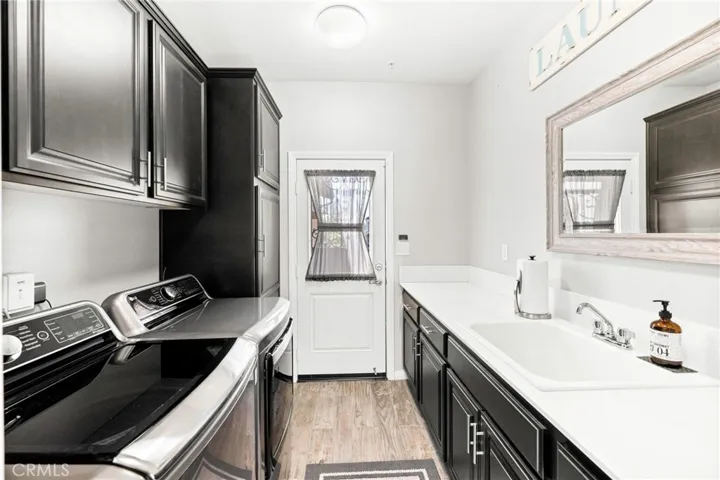 Convenient downstairs laundry room:
The downstairs laundry room offers thoughtful functionality with a built-in sink, abundant cabinetry, and direct exterior access to the front of the home.