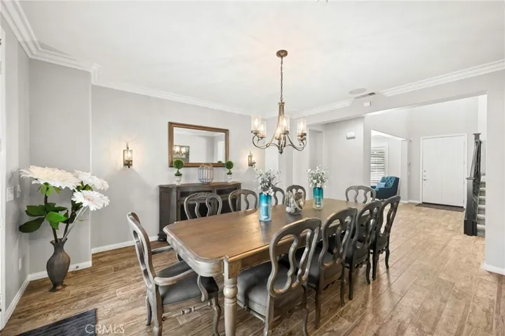 Elegant formal dining room:
Notice the sophisticated formal dining area, adorned with an exquisite chandelier, detailed crown molding, and elegant baseboards that elevate the space. French doors open to the beautifully landscaped backyard, creating a seamless transition between refined indoor dining and inviting outdoor living.