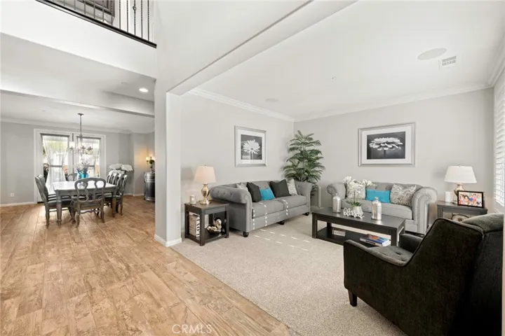 Grand entryway with soaring ceilings:
Upon entering, you’re greeted by an impressive foyer with dramatic high ceilings and abundant natural light that fills the space. To the right, the formal living room offers an elegant setting for gatherings, while the formal dining room ahead provides a graceful backdrop for entertaining. The open loft above adds architectural interest and a sense of grandeur to this stunning entry.