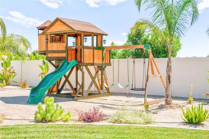 Dedicated play area:
A separate outdoor space features a charming wooden swing set, thoughtfully positioned to create a safe and inviting play area. Surrounded by the home’s beautifully landscaped grounds, it offers the perfect spot for children to enjoy the outdoors in style and comfort.