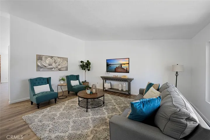 Spacious living room with newer luxury vinyl plank flooring. Newly painted and newer double pane flooring. Ceiling height gets to about 10 feet.