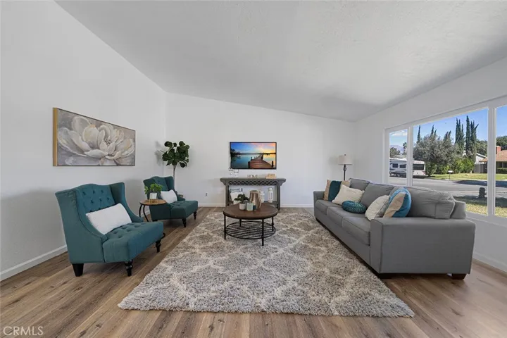 Spacious living room with newer luxury vinyl plank flooring. Newly painted and newer double pane flooring. Ceiling height gets to about 10 feet.