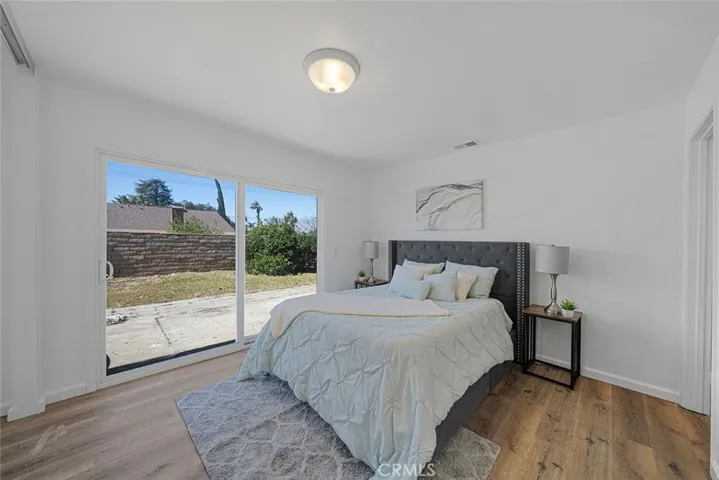 Primary bedroom updated with flooring, paint, lighting, double pane slider to the backyard.