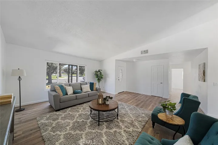 Spacious living room with newer luxury vinyl plank flooring. Newly painted and newer double pane flooring. Ceiling height gets to about 10 feet.